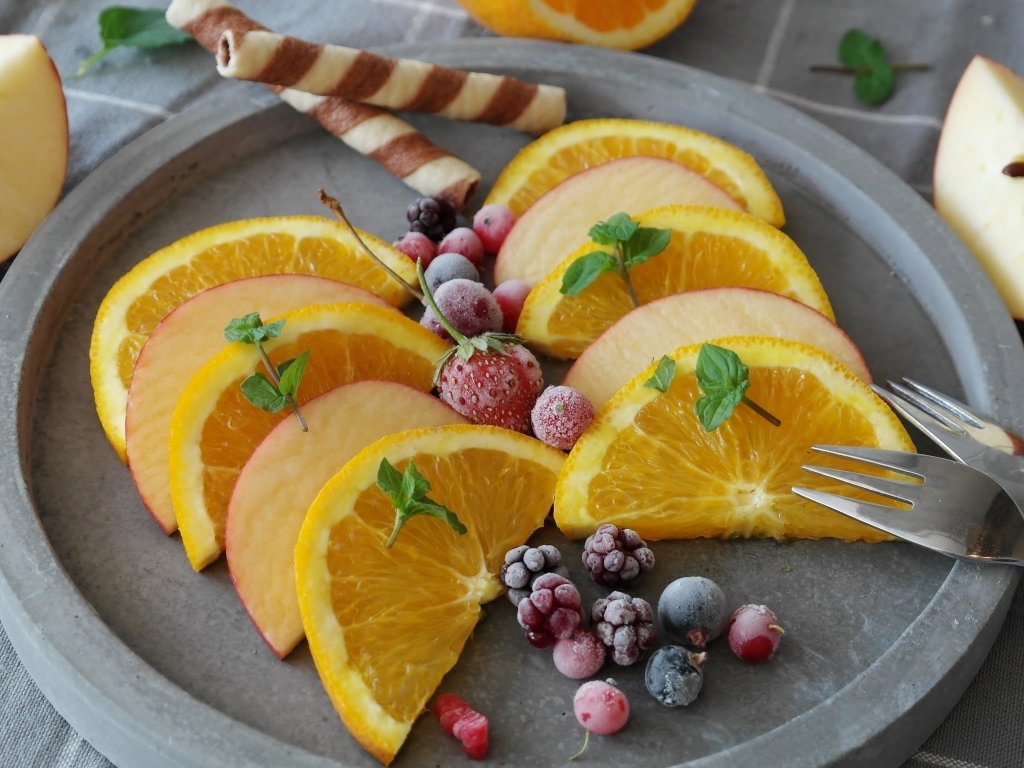 Кусочки апельсина с яблоком и замороженными ягодами