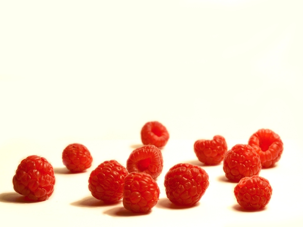 Красные ягоды малины на белом фоне крупным планом