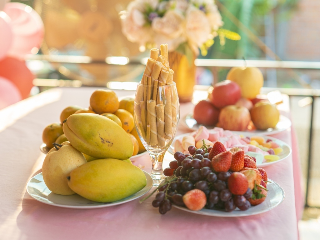 Спелые сладкие фрукты и ягоды на столе с трубочками