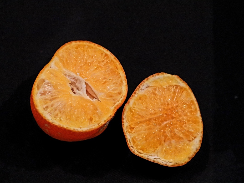 Мандарин на черном фоне крупным планом