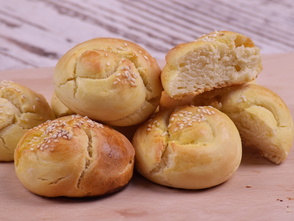 Аппетитные сладкие булочки с кунжутом на столе