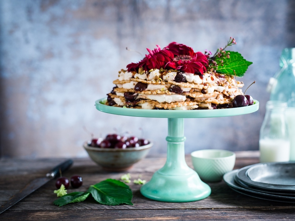 Торт с черешней и цветами герберы на столе