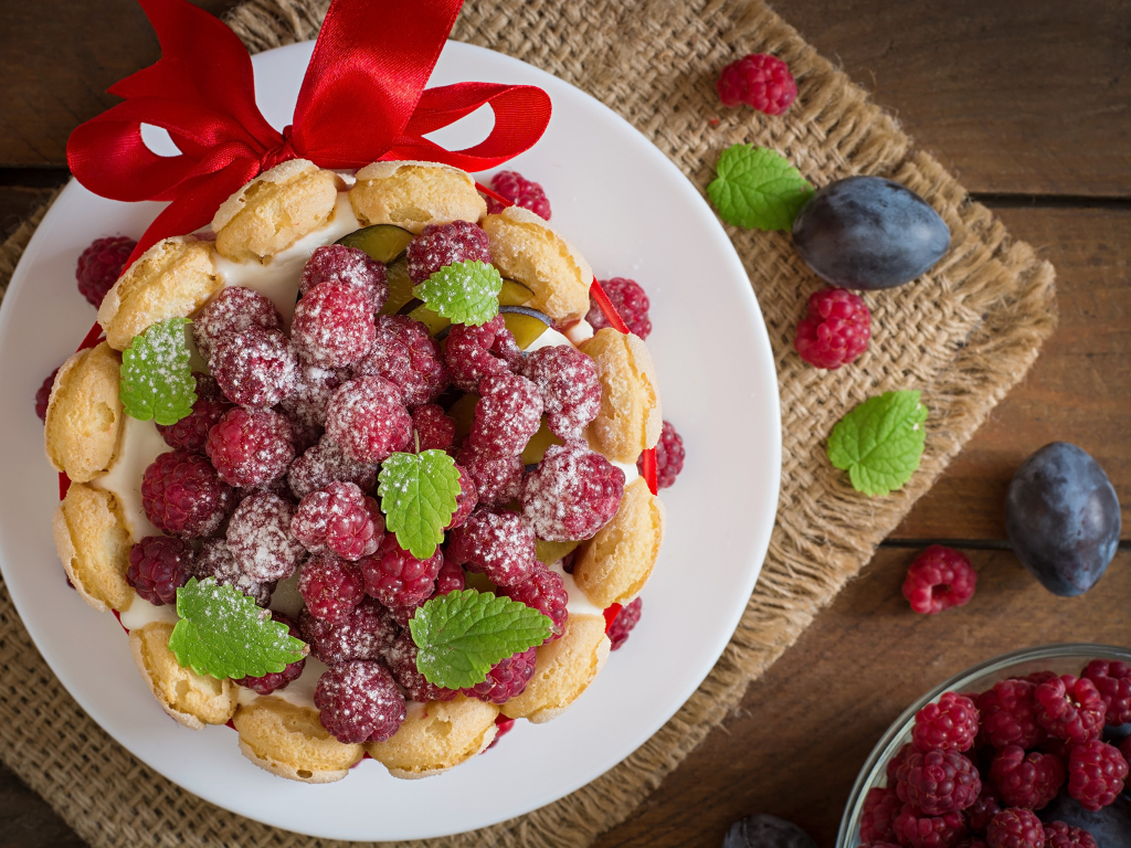 Пирожное с кремом и ягодами малины с ленточкой