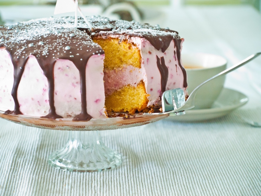 Торт с розовым кремом и шоколадом на столе