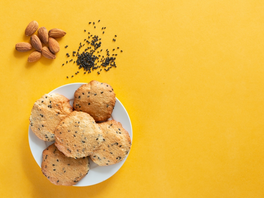 Печенье на желтом фоне с кунжутом и миндальным орехом