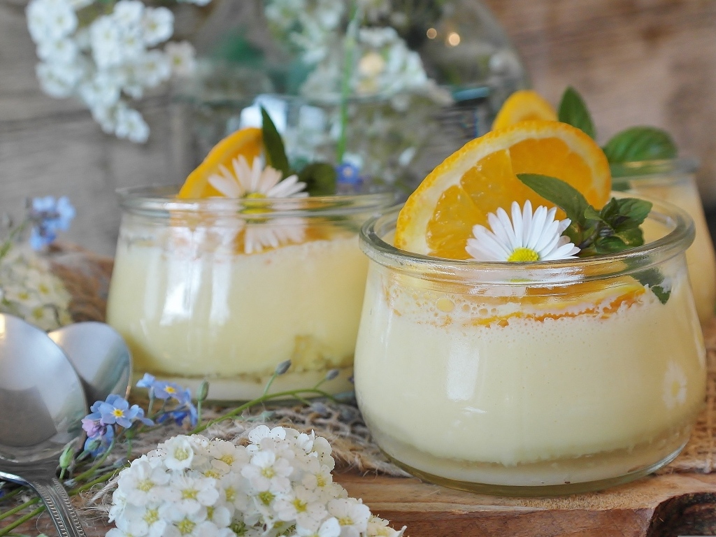 Лимонный крем в стеклянных банках на столе с цветами