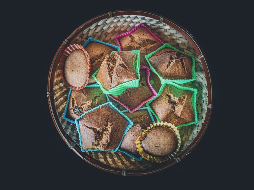 Много кексов в корзине на черном фоне