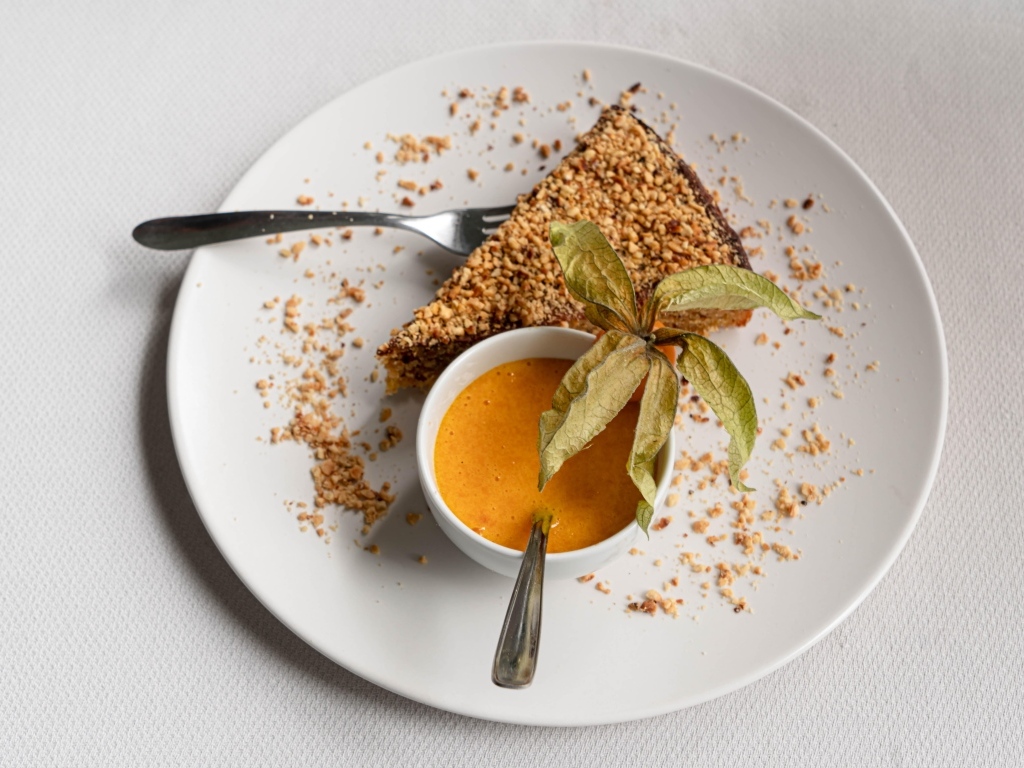 Кусок торта на белой тарелке с соком 