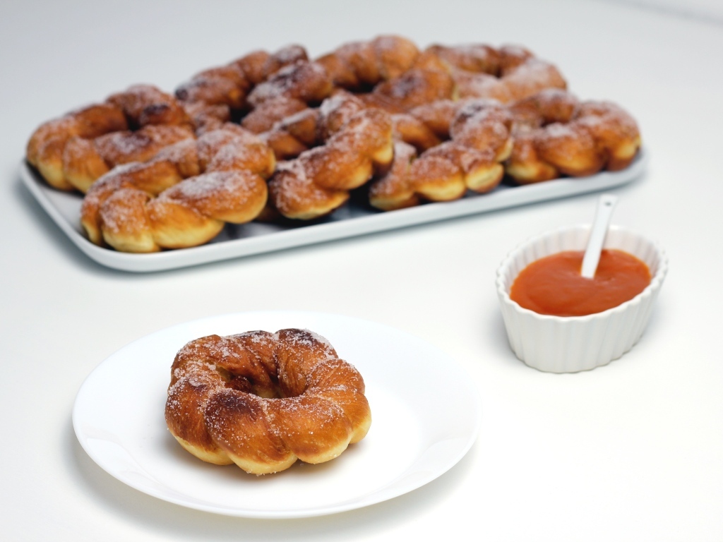 Сладкие пончики в сахарной пудре на столе