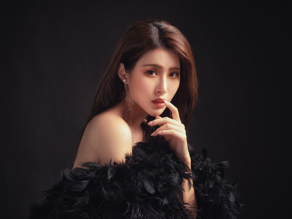 Девушка азиатка в боа на черном фоне