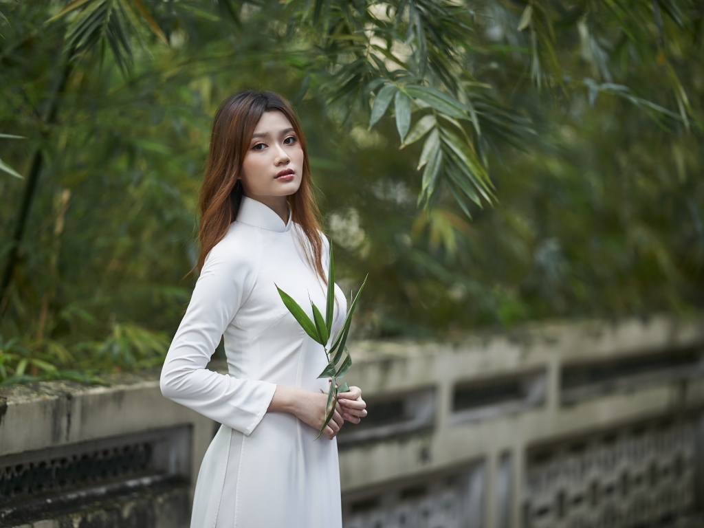 Девушка азиатка в белом наряде в парке