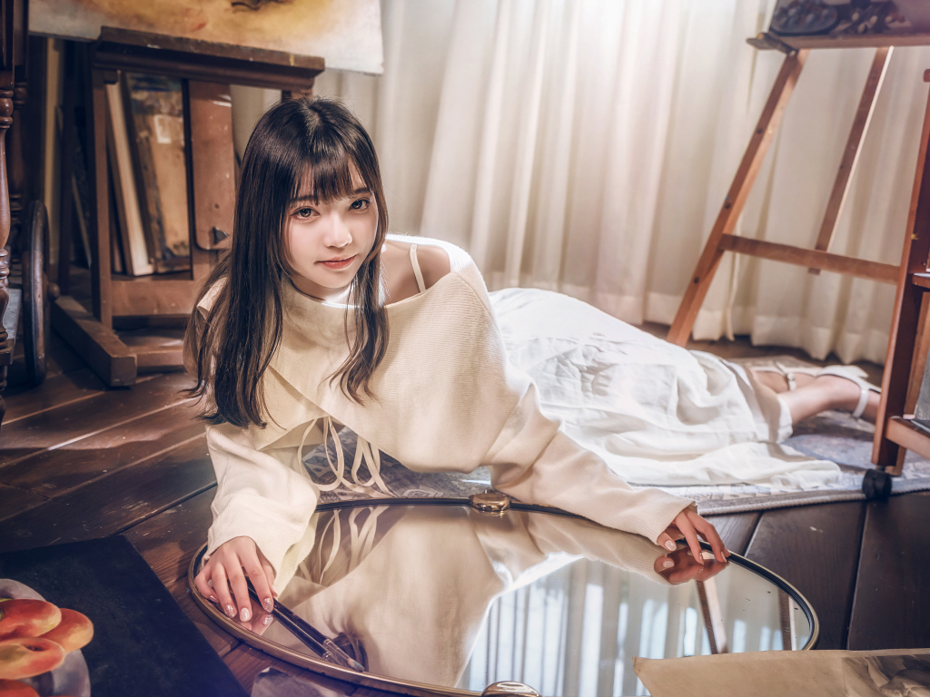 Девушка азиатка в белом платье лежит на полу