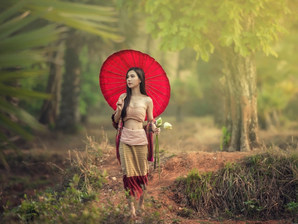 Девушка азиатка с красным зонтом и цветами лотоса