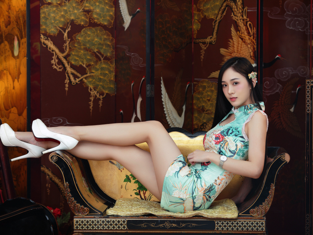 Красивая девушка азиатка лежит на диване