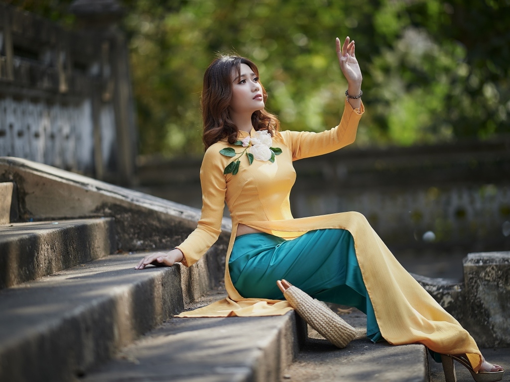 Красивая девушка азиатка сидит на ступеньках