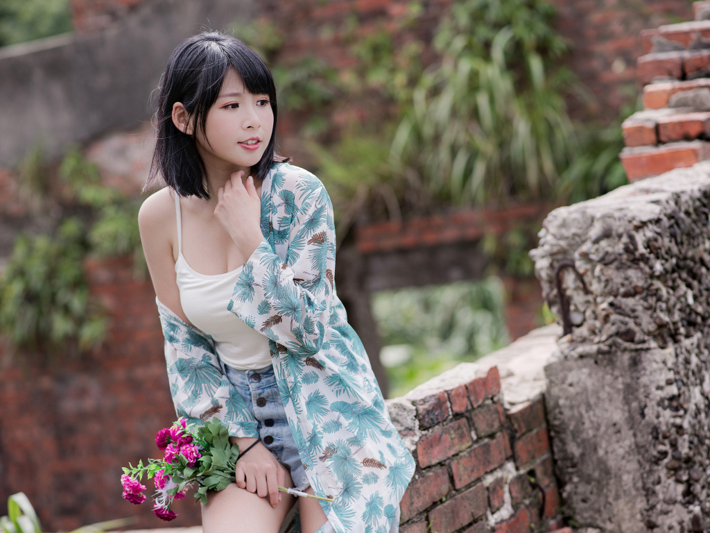 Красивая азиатка с цветком в руке