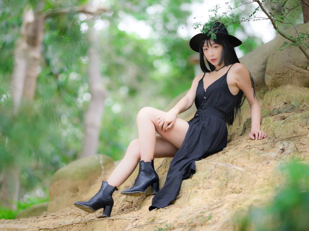 Красивая девушка в черном платье и шляпе