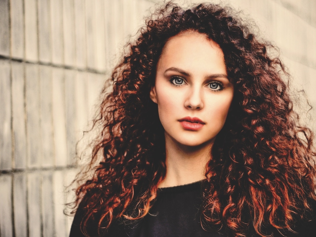 Кудрявые красивые волосы у девушки с серыми глазами