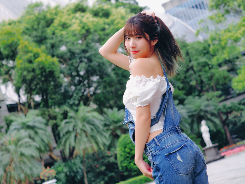 Милая девушка азиатка в джинсовом комбинезоне