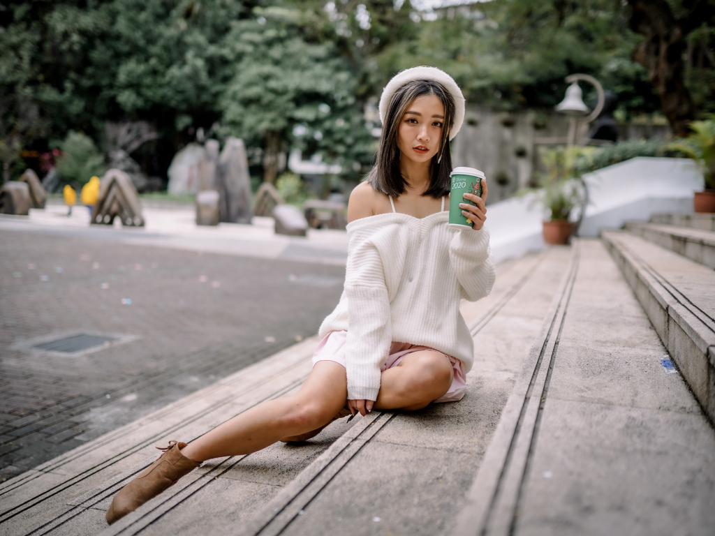 Милая азиатка в с кофе в руках 