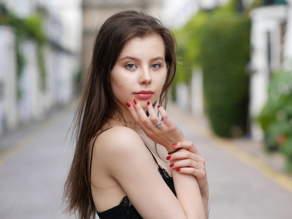 Милая голубоглазая девушка с красным маникюром