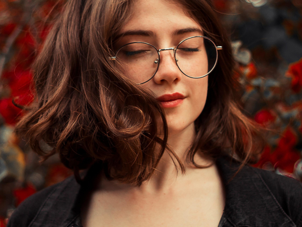 Мечтательная девушка в очках с закрытыми глазами
