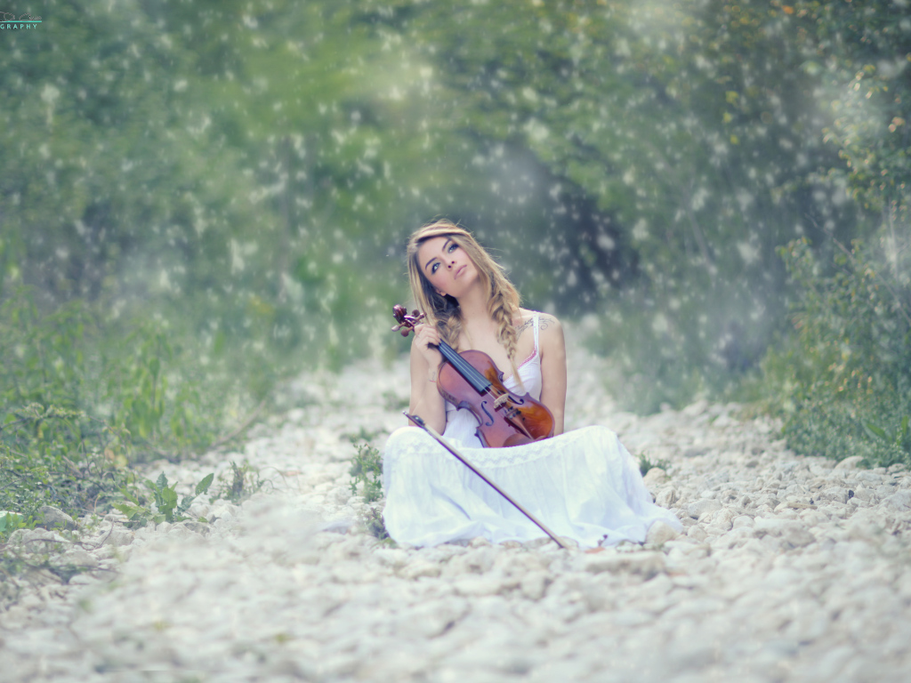 Девушка со скрипкой в руках в лесу