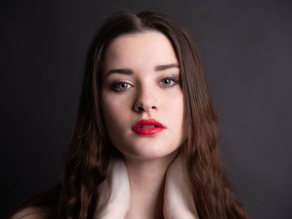 Девушка с красными губами на сером фоне