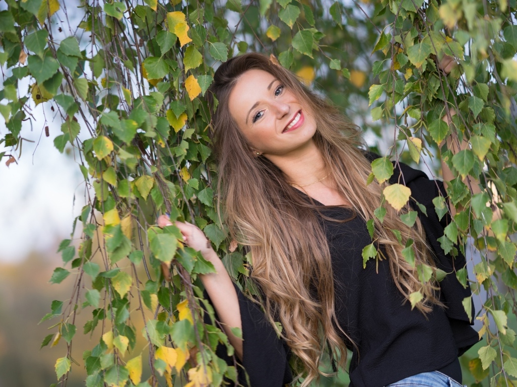 Улыбающаяся девушка в ветках березы