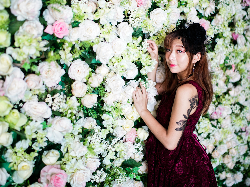 Молодая азиатка на фоне стены с розами
