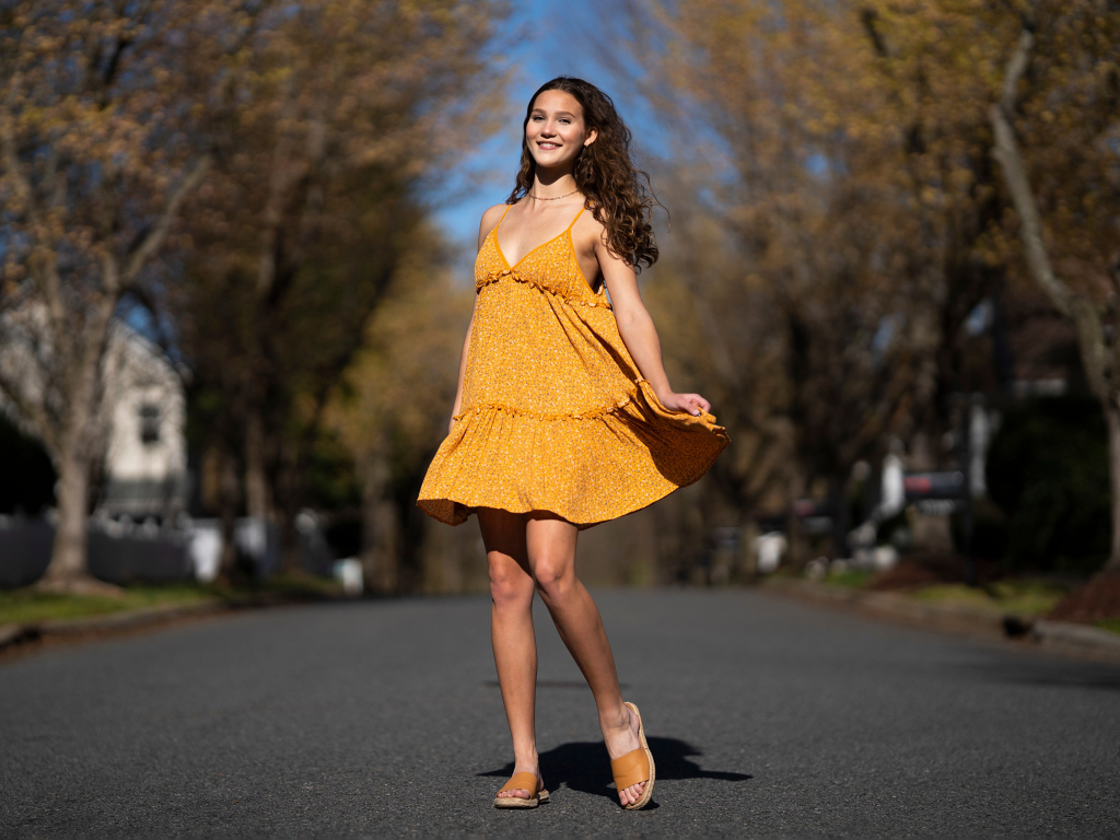 Молодая девушка в коротком платье на дороге  летом