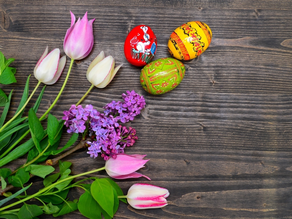 Пасхальные яйца с живыми цветами на столе 