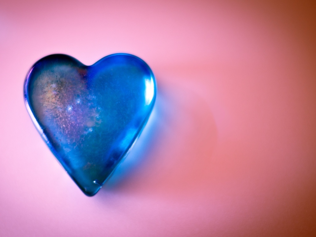 Синее стеклянное сердце на розовом столе