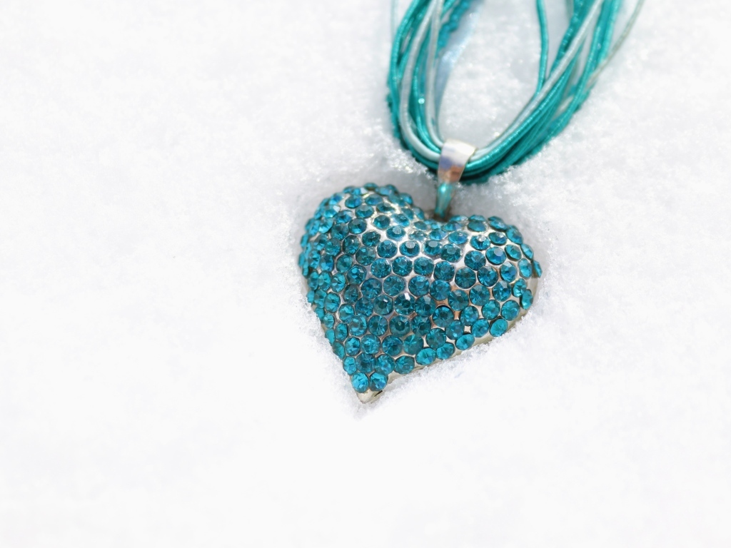 Голубой кулон в форме сердца на снегу