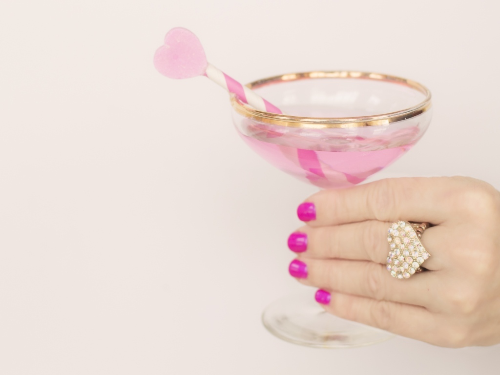 Кольцо в форме сердца на руке девушки с бокалом