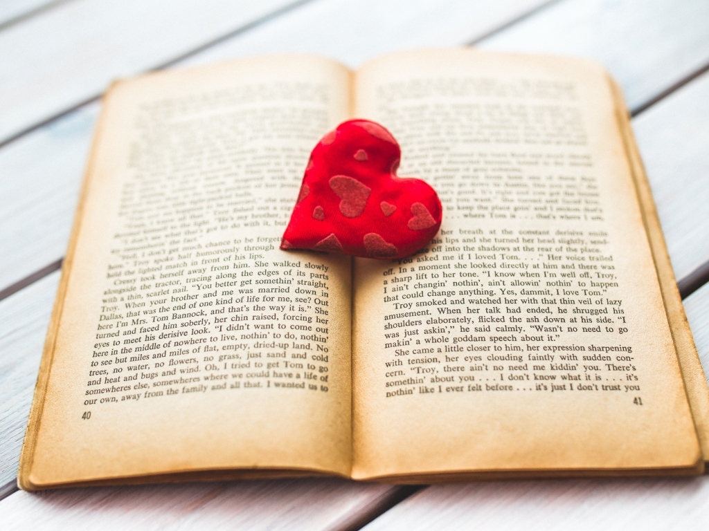 Маленькое красное сердце с книгой на столе