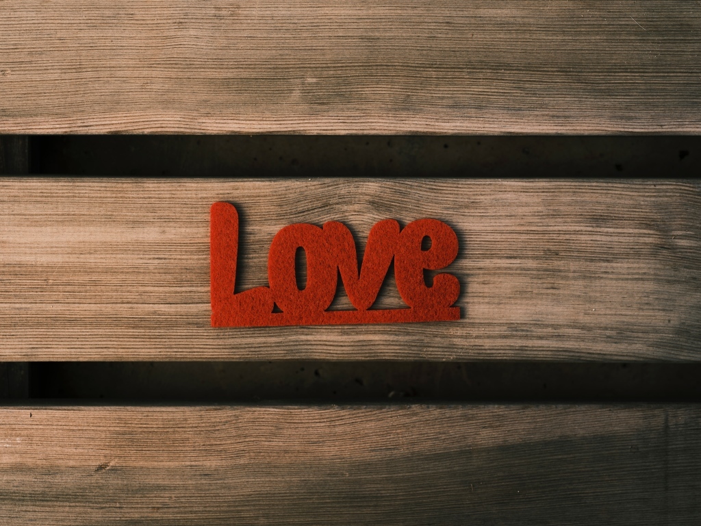 Красная надпись любовь на деревянном фоне