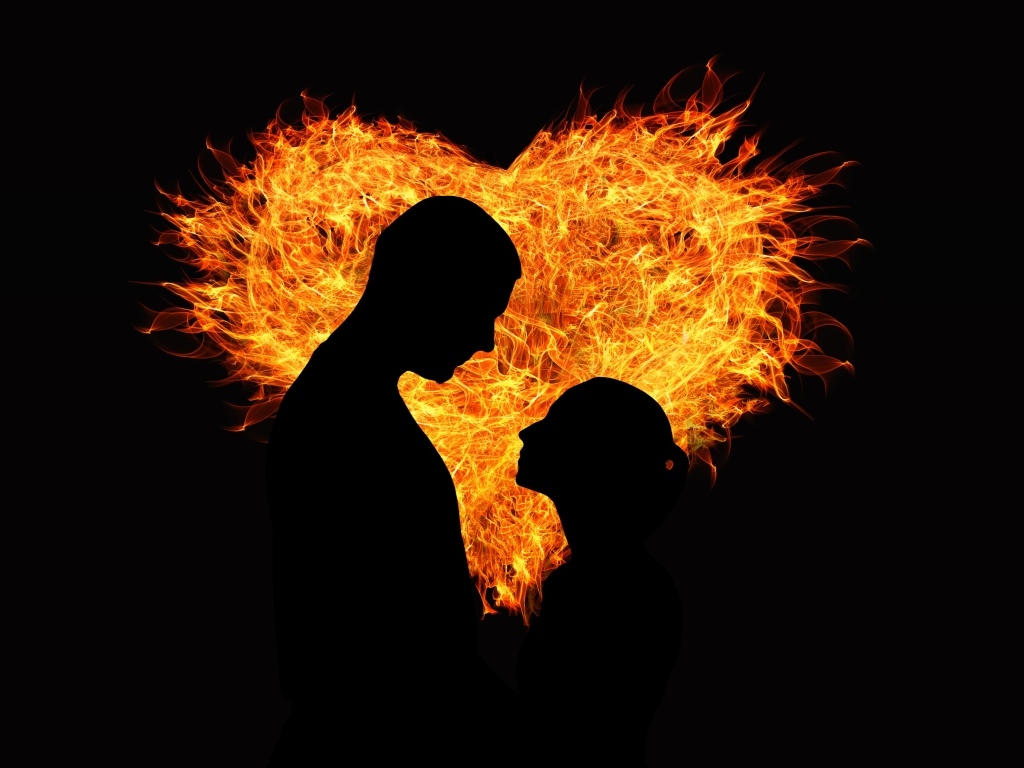 Силуэт влюбленной пары на фоне огненного сердца