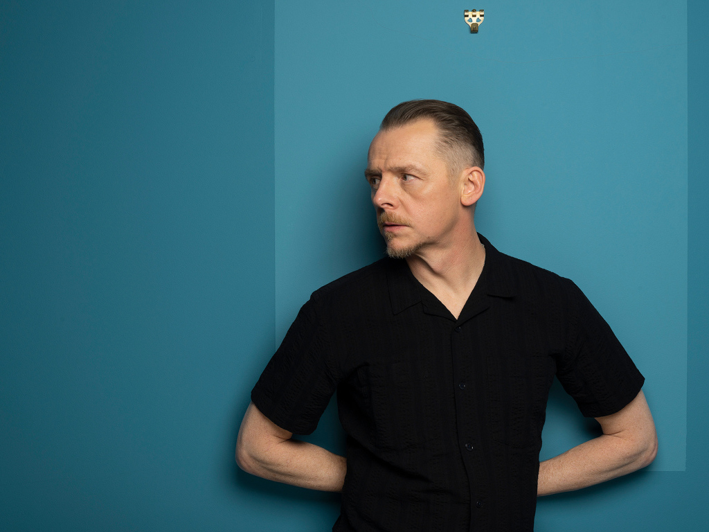 Актер Саймон Пегг  стоит у стены