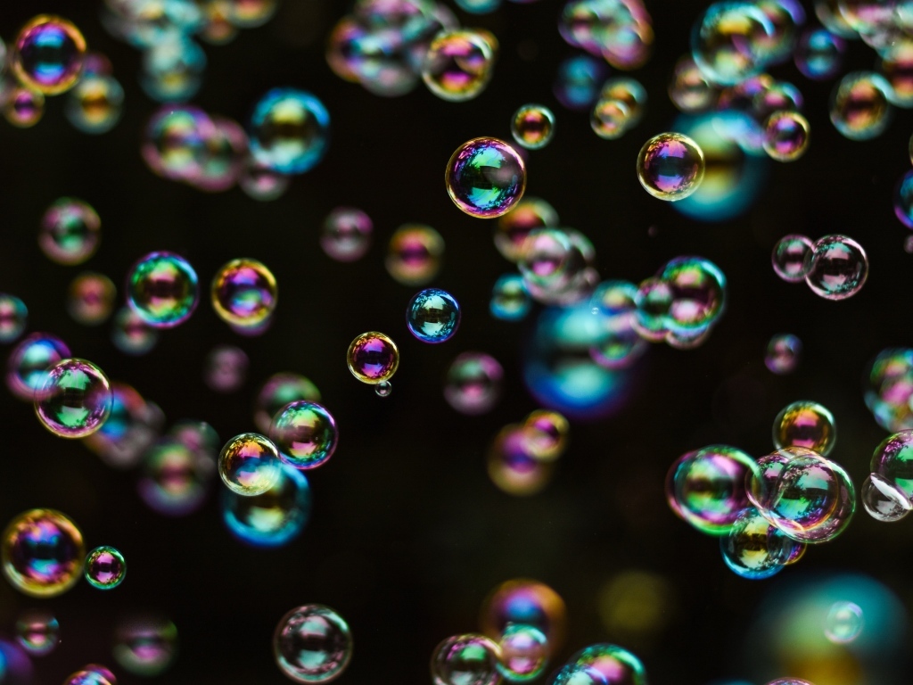 Разноцветные мыльные пузыри на черном фоне