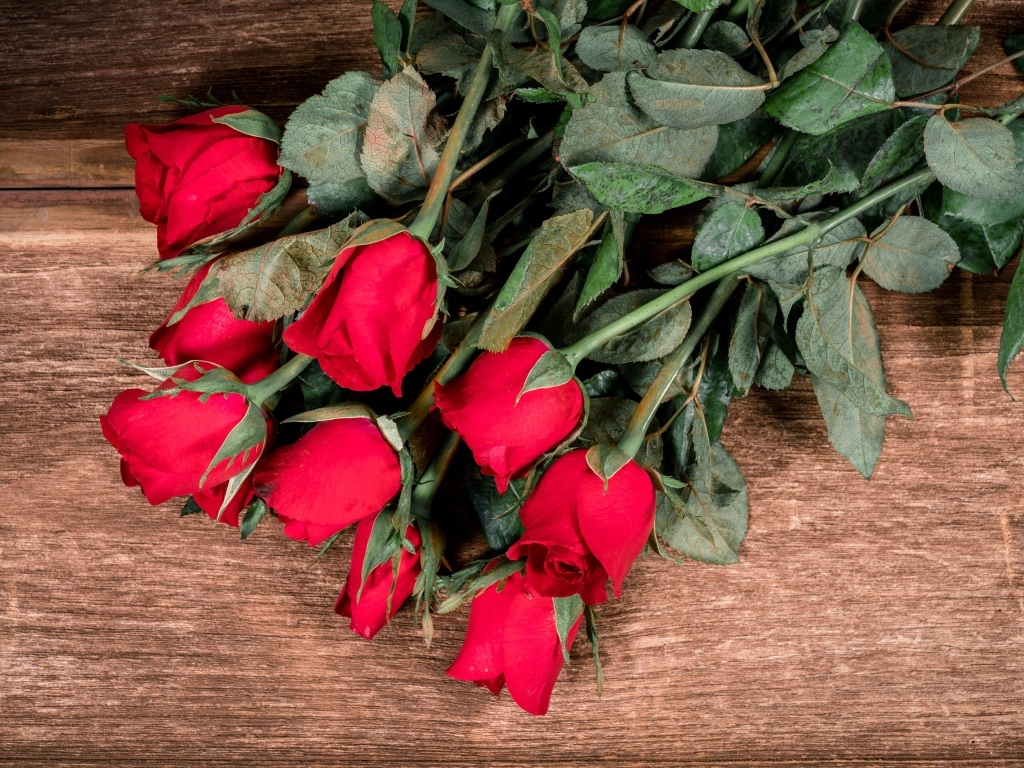 Букет красных английских роз на деревянном столе