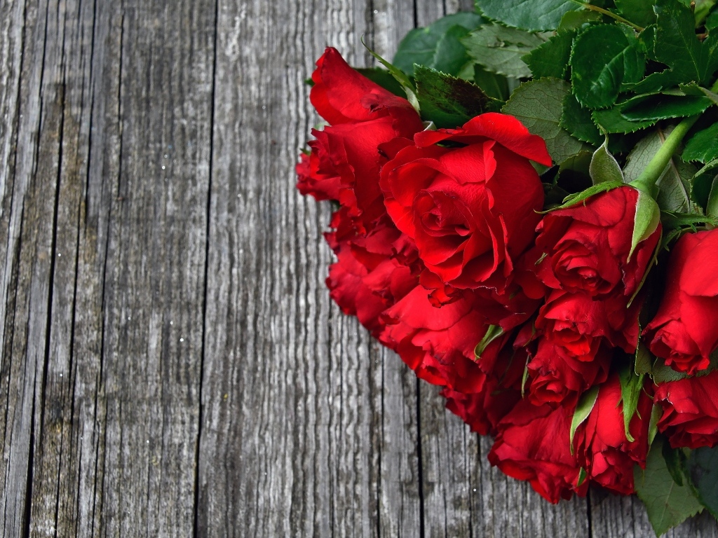 Букет красных роз на деревянном столе