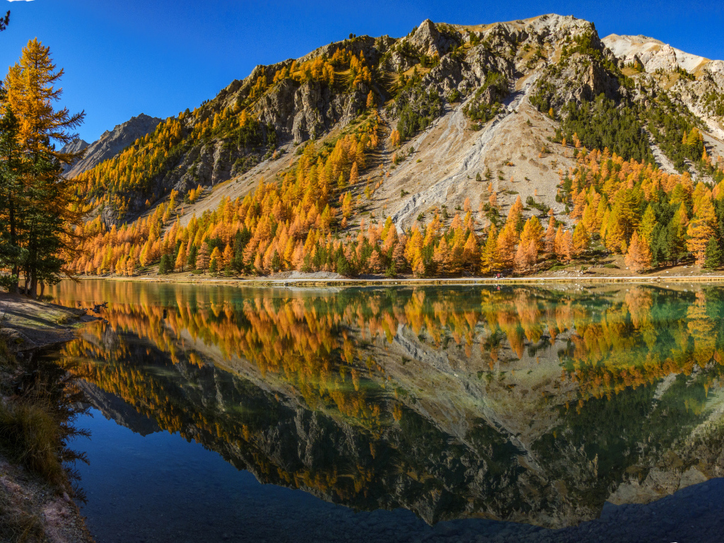 The Alps are reflected in the water in autumn
