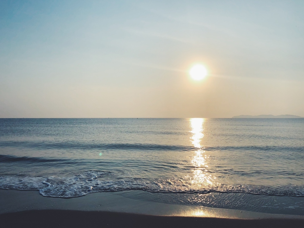 Яркое солнце над спокойным морем летом