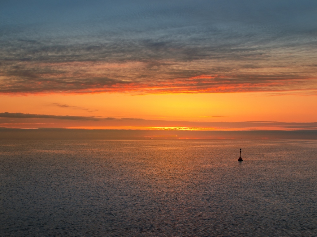 Яркий оранжевый закат на морском горизонте