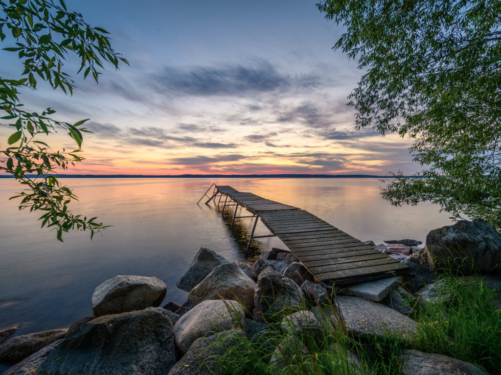 Старый деревянный пирс у озера на закате