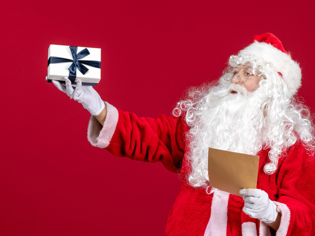 Санта Клаус с письмом на красном фоне