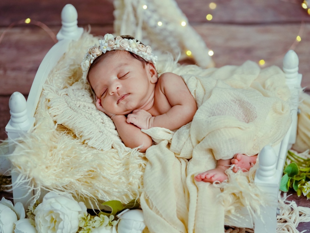 Красивая новорожденная девушка с венком на голове 