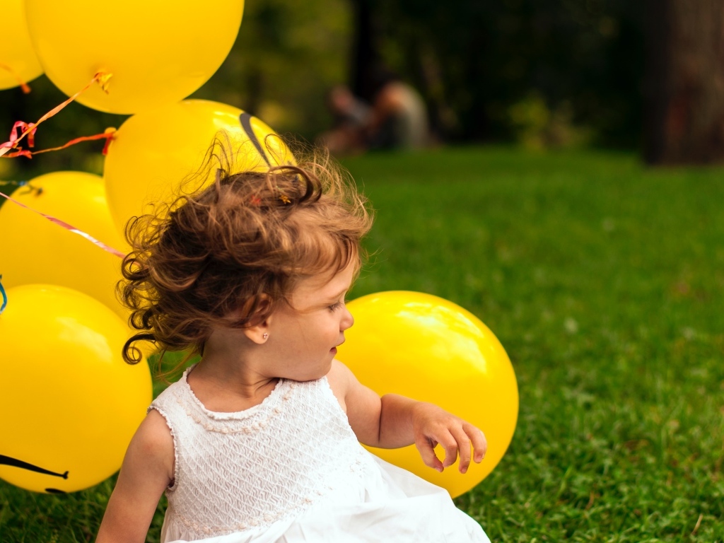 Маленькая девочка с желтыми шариками