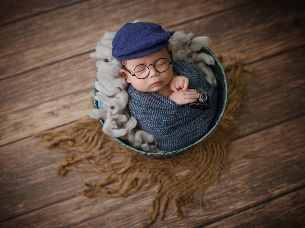 Маленький новорожденный ребенок в очках и кепке 